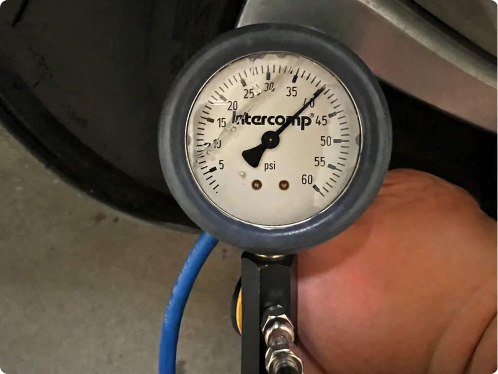 Analog tire-pressure gauge showing approximately 40 PSI during DEWALT inflator testing